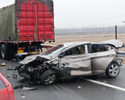 A severely damaged car is lodged beneath the rear of a semi truck after a collision, illustrating the serious impact of a Dallas truck accident and the role of shared fault under Texas comparative negligence laws