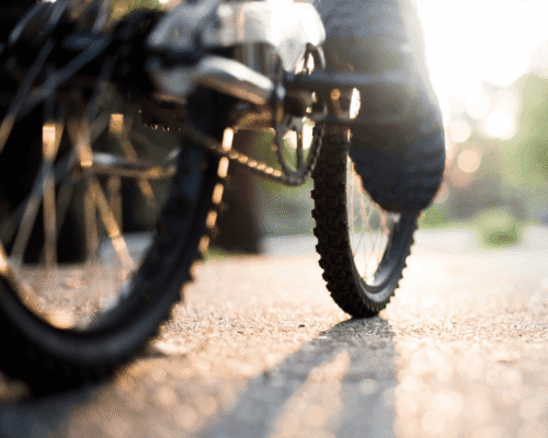 Close-up of bicycle wheels on a sunlit path