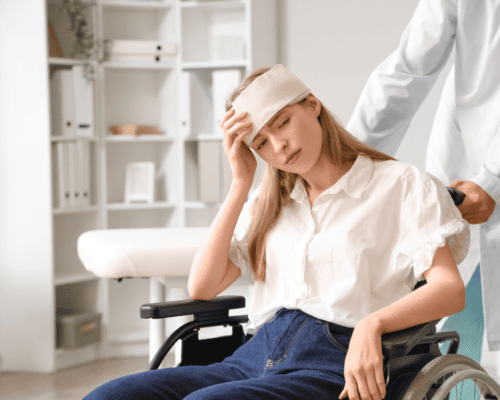 Young woman with a head injury sitting in a wheelchair while receiving medical care, illustrating the long-term impact and costs of traumatic brain injury claims in Dallas personal injury cases.
