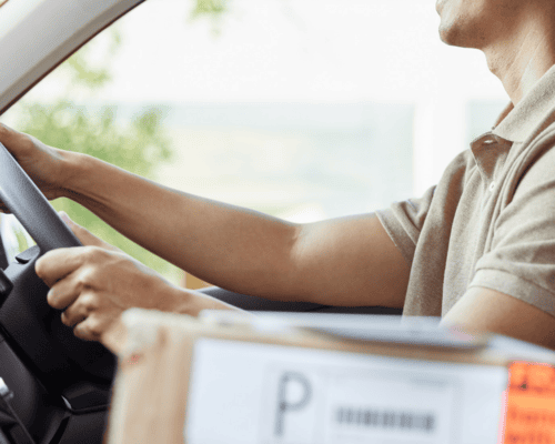 Delivery driver behind the wheel in a Dallas residential neighborhood, highlighting driver negligence and liability issues in a Dallas delivery truck accident.